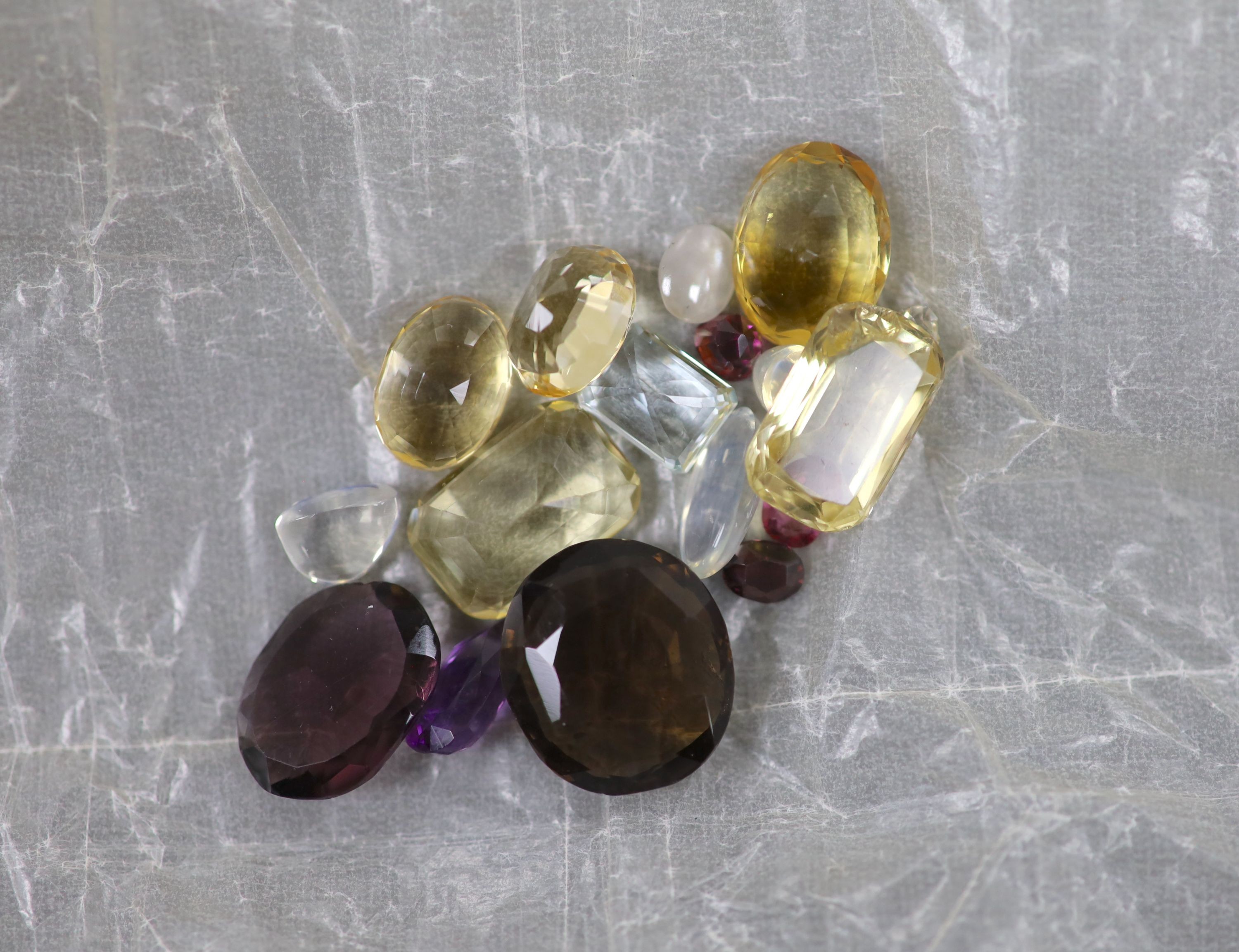 A quantity of assorted loose cut gemstones including sapphires, aquamarine, citrine and tourmalines.
